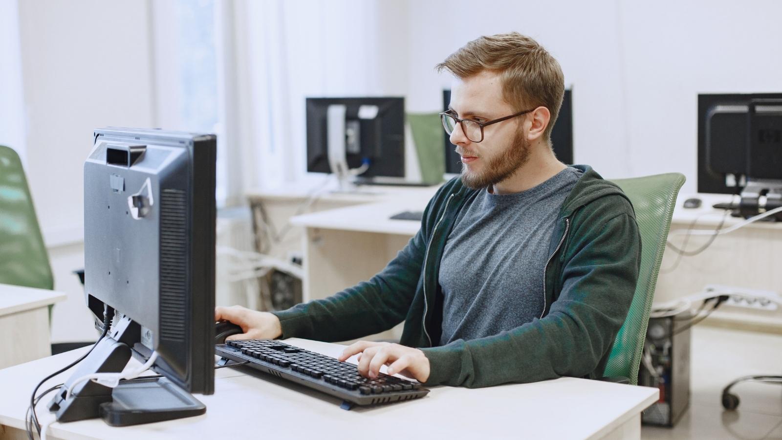 Im on My Lunch: Punished IT Employee Sparks Total Corporate Chaos After Following His Bosss Strict Break Schedule to the Exact Minute IT worker sitting in front of computer monitors