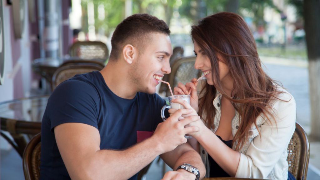Man and woman happily sharing a milkshake