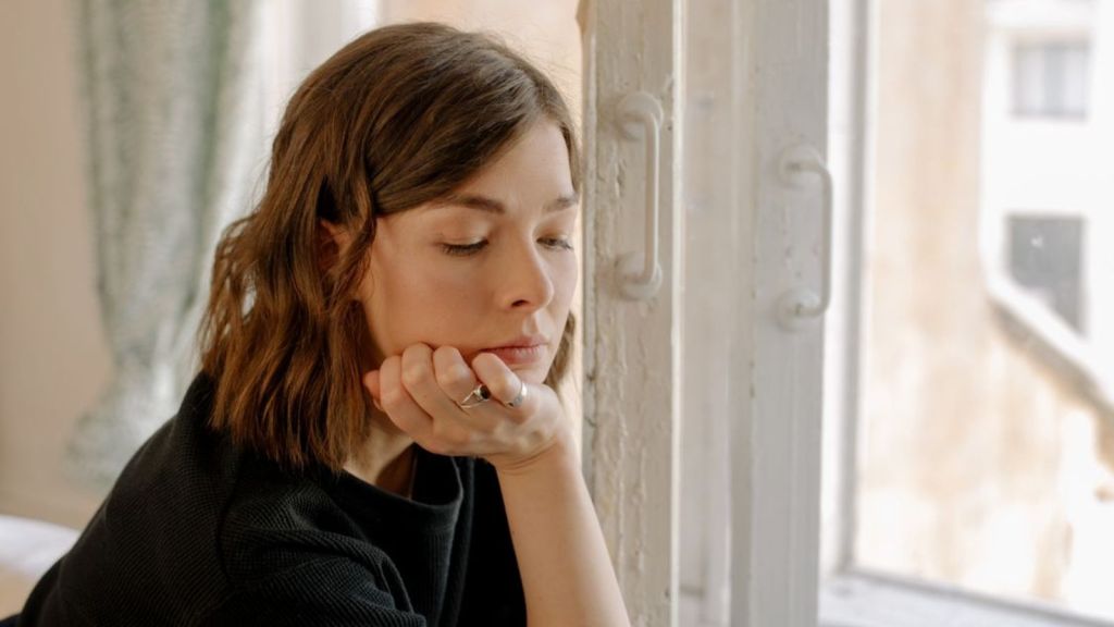 Sad woman contemplating about life near a window