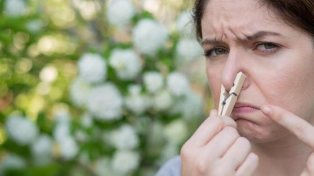 Woman holding her nose