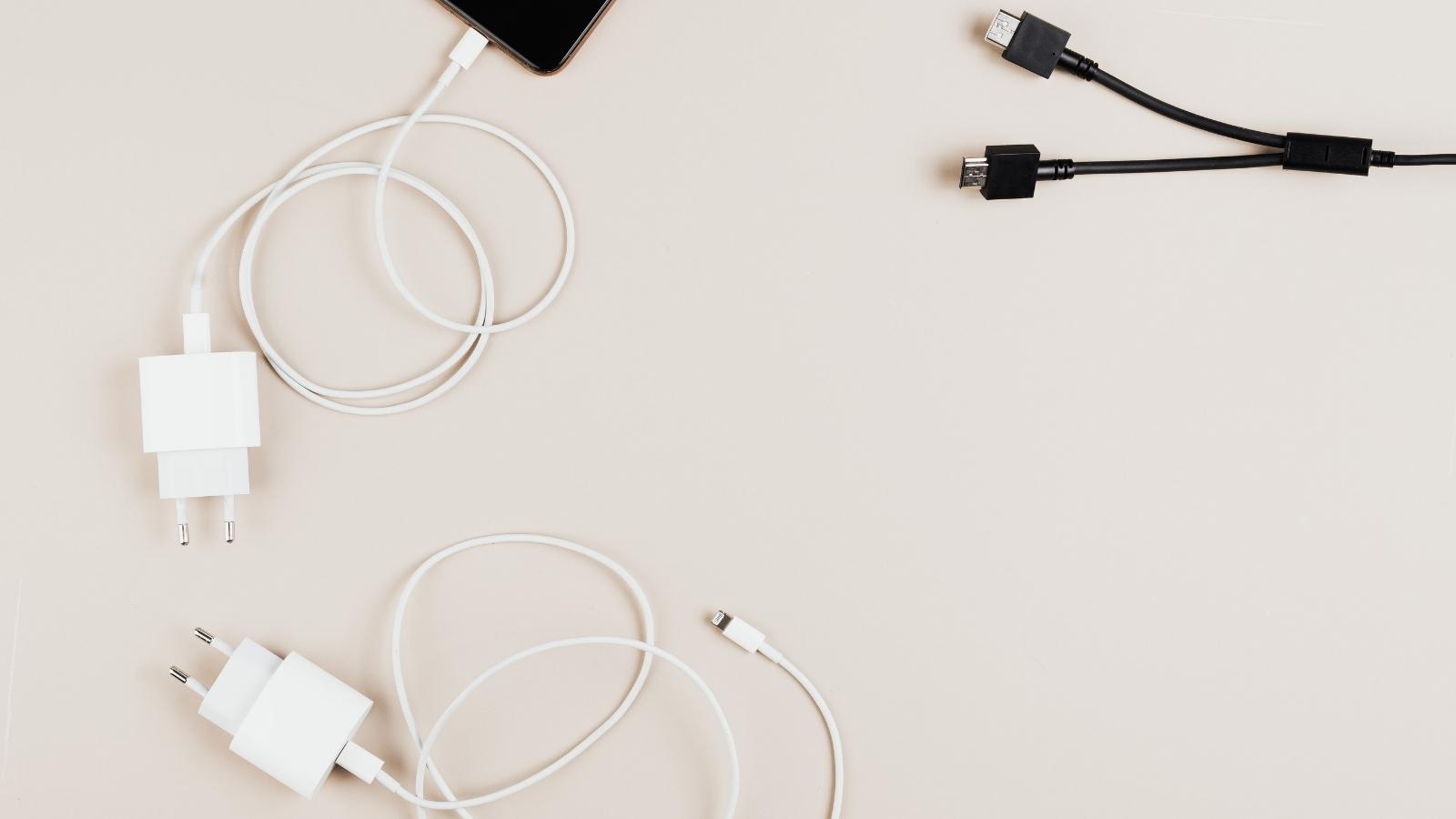 Phone chargers for Apple phones laying on beige background