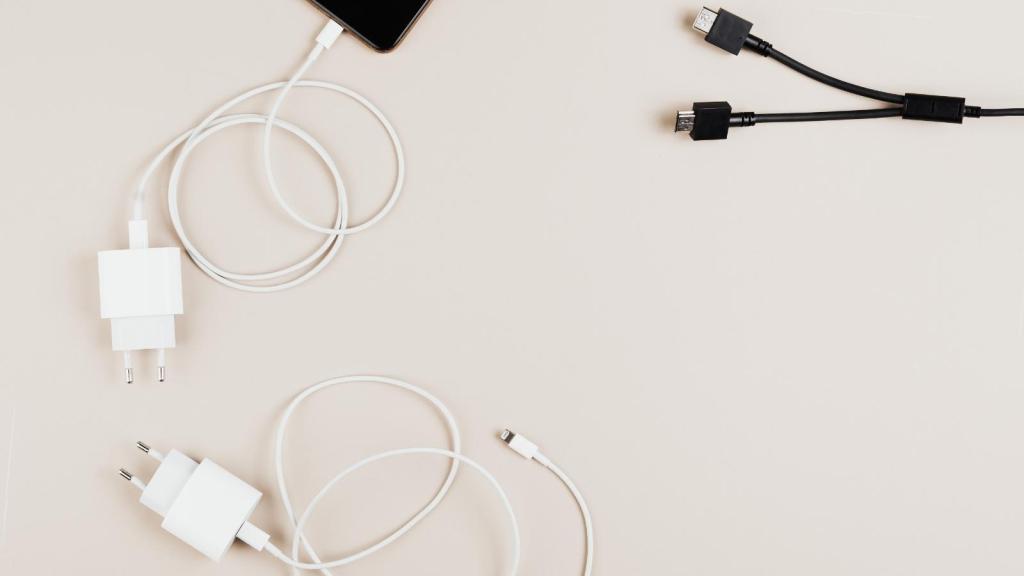 Phone chargers for Apple phones laying on beige background