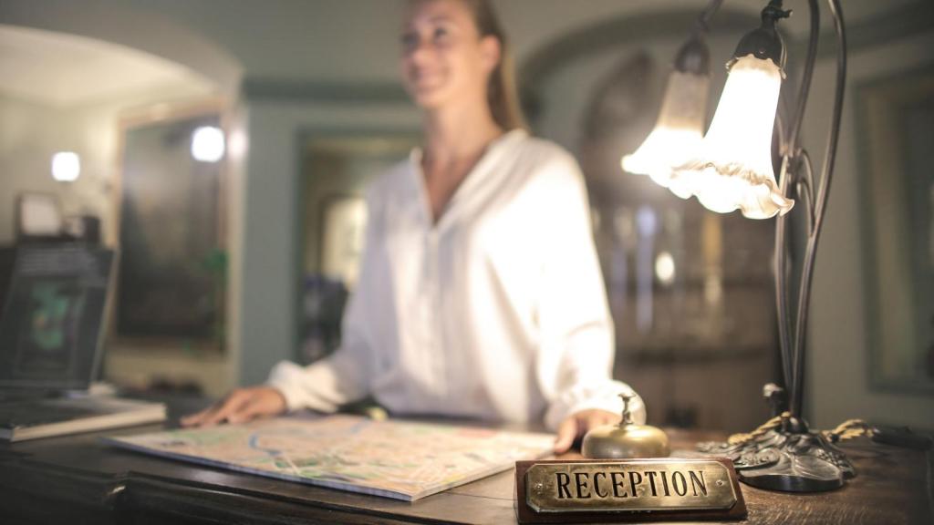 Woman standing at front desk by her bell