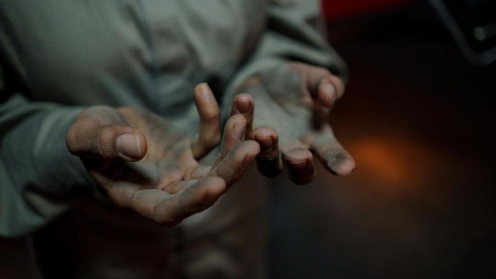 Man holding out his dirty hands after long day at work