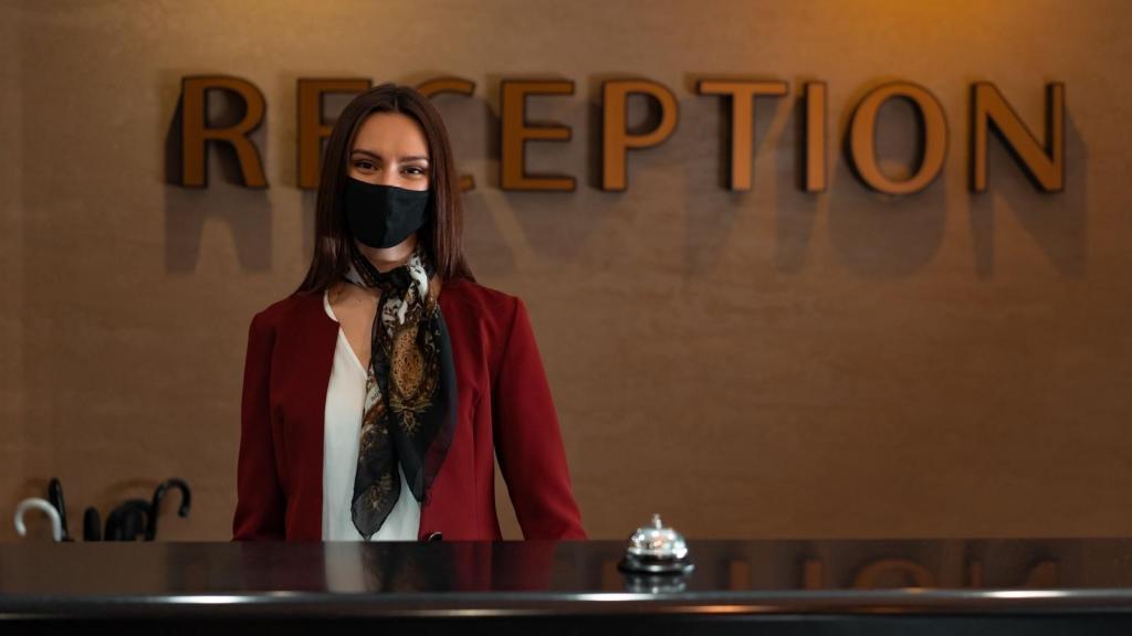Woman wearing a mask and working front desk