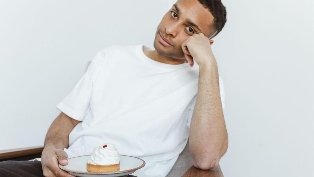 Man holding a cake and thinking if he was wrong