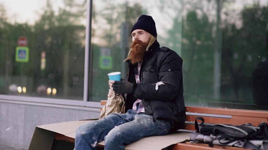 Homeless man sitting in front of a business