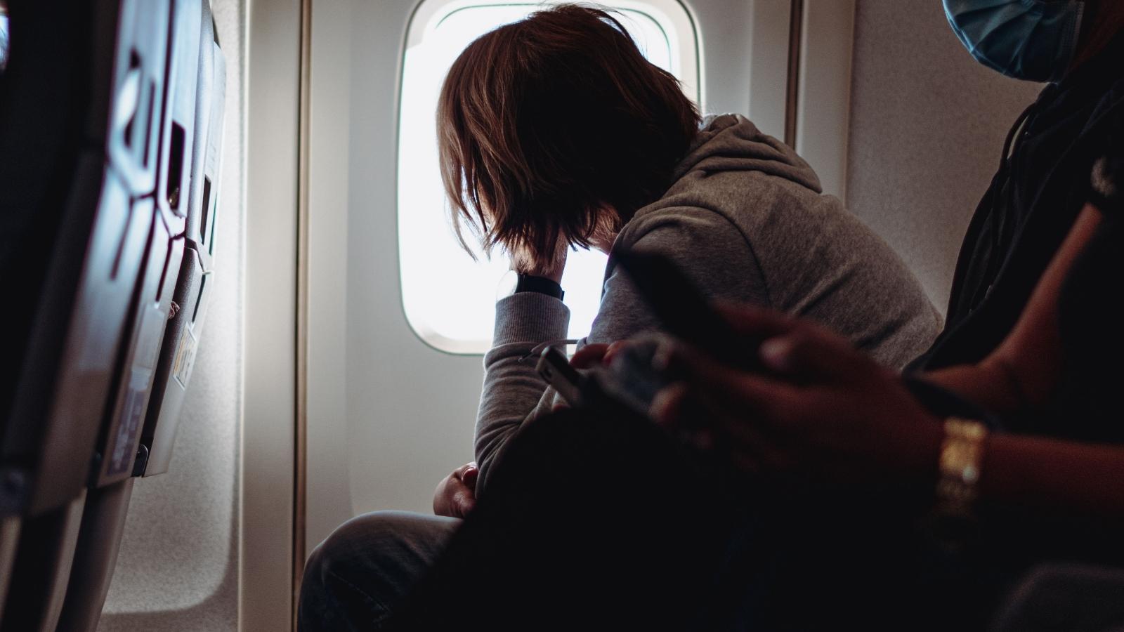 Man staring out the window of a plane