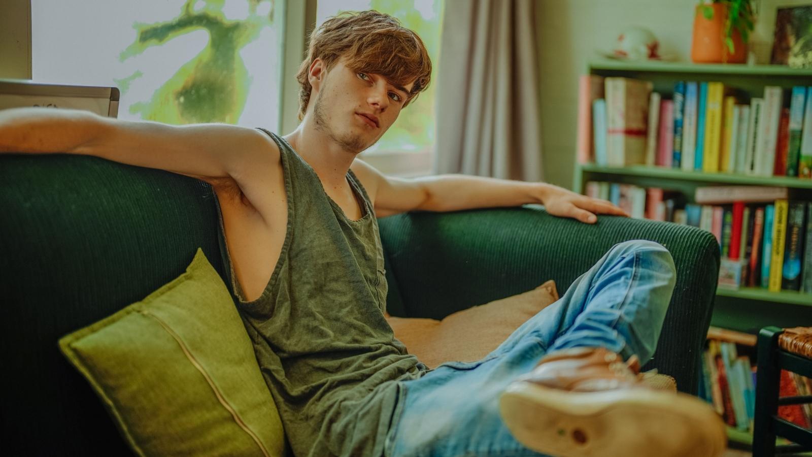 Young man sitting on the couch thinking