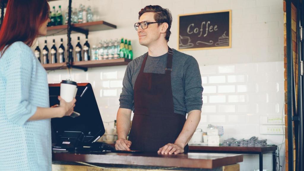 Man cashier smiling and helping a customer