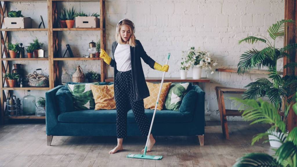 Woman having fun cleaning with a broom