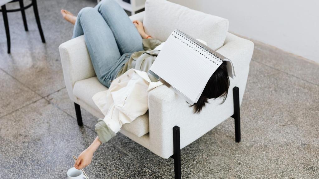 Woman tired in a chair trying to work
