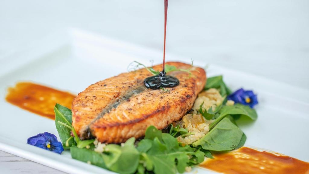 Glaze being poured over a nice piece of cooked salmon