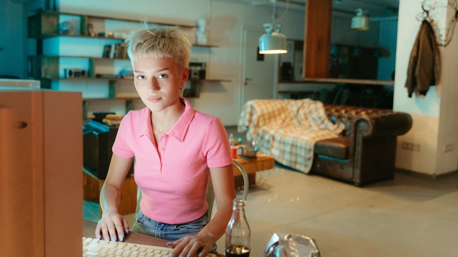 Woman on her computer in a pink shirt