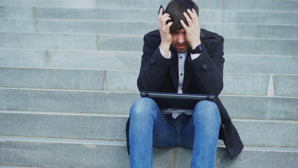 Man sitting on steps outside having a meltdown