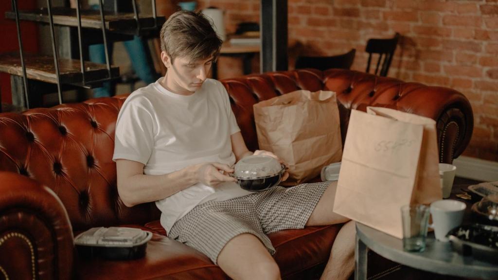 Man sitting on the couch enjoying his takeout
