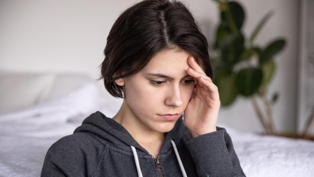 Woman holding her forehead due to stress