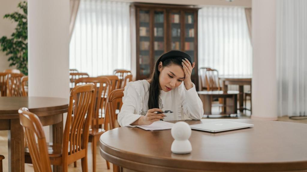 Woman sitting at a table, frustrated by a situation