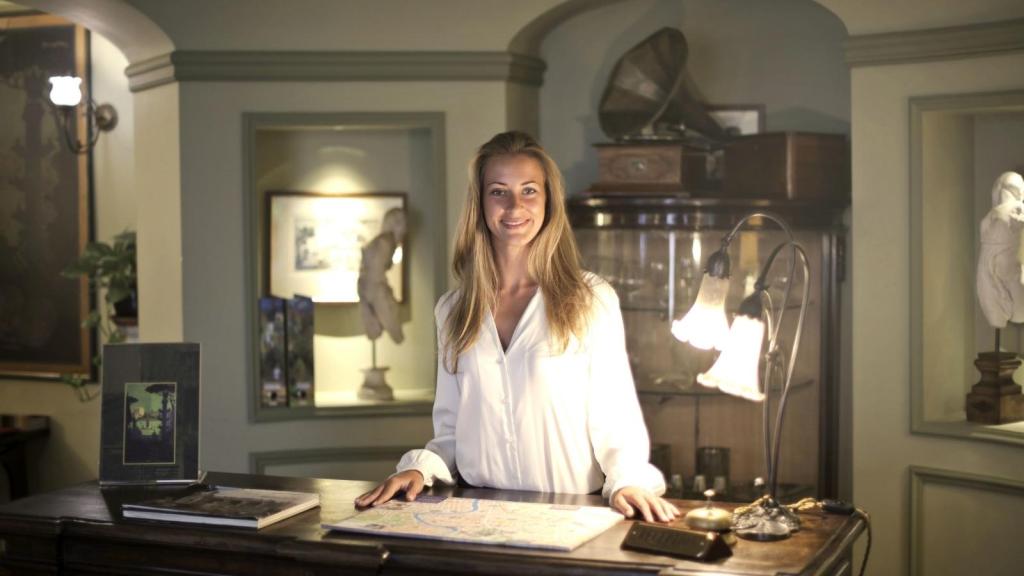 Blonde woman standing at hotel front desk