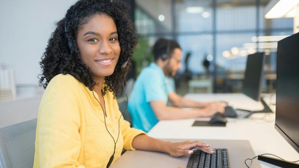 Call center agent smiling after dealing with rude woman