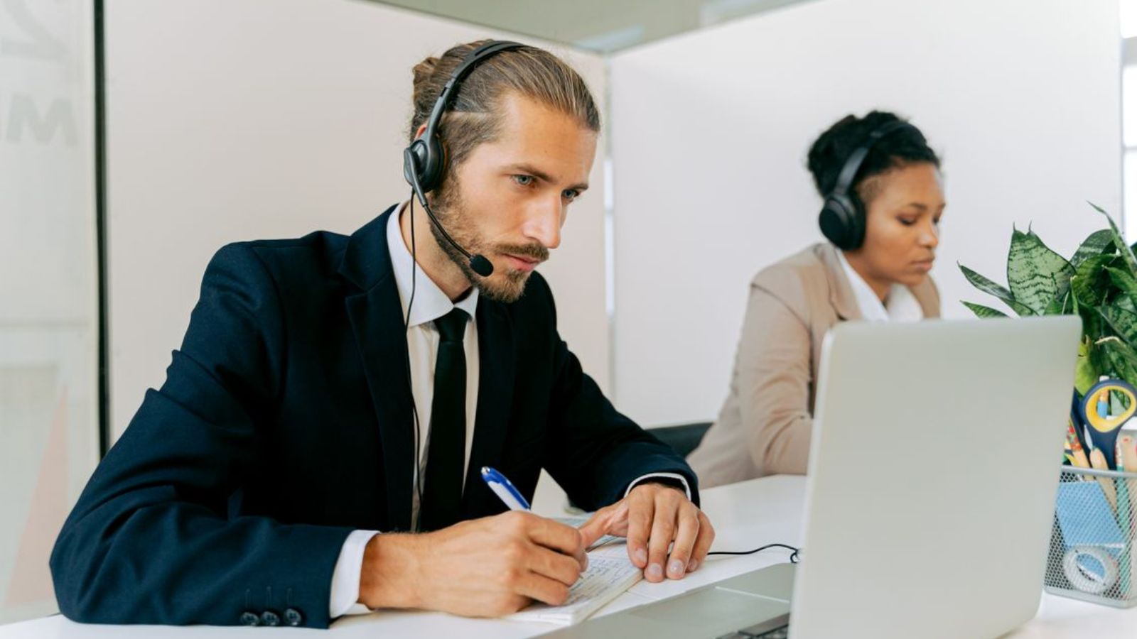 The IT Officer Clarified the Boundary Multiple Times, but the User Insisted He Fix an Out of Scope Login Problem Tech support officer writing on his notebook while looking at the computer screen