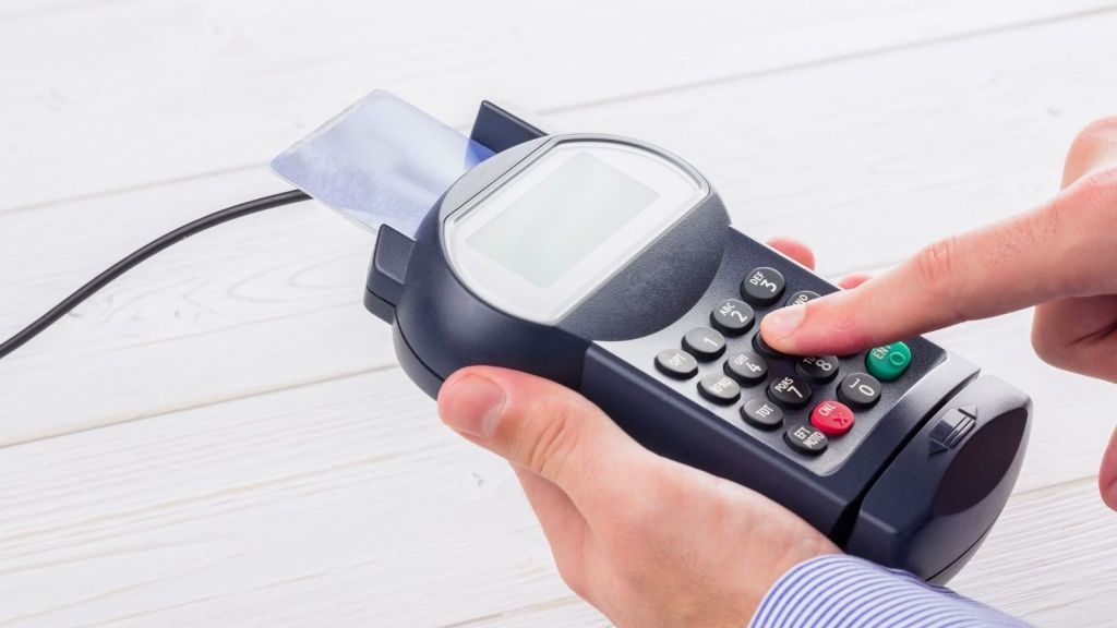 man paying with credit card on a pin pad