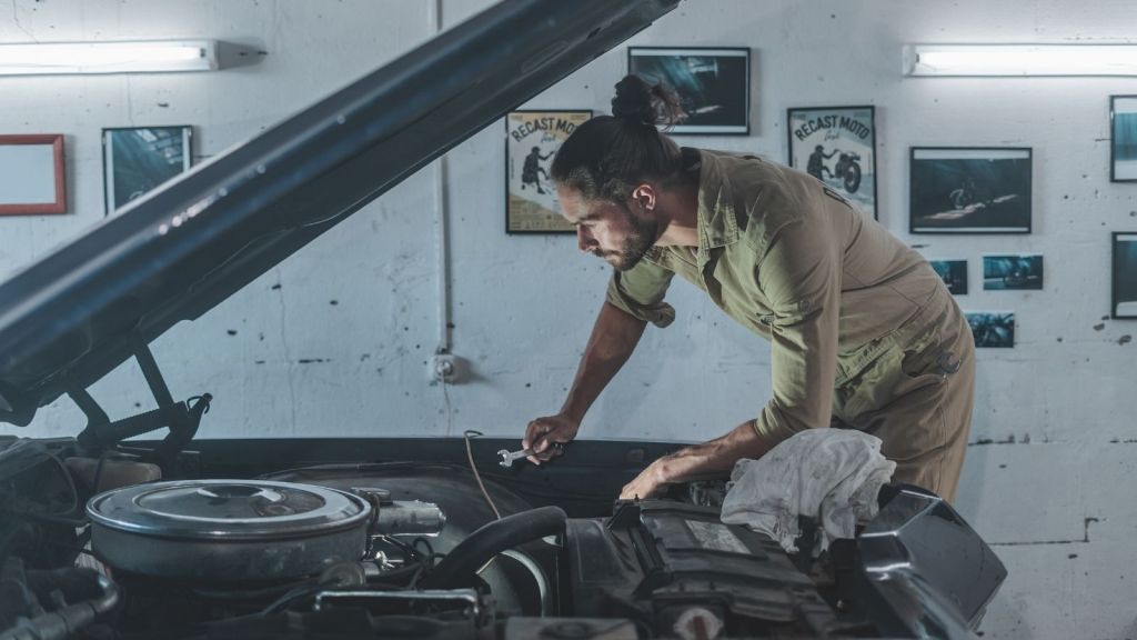 man working on a car in his garage