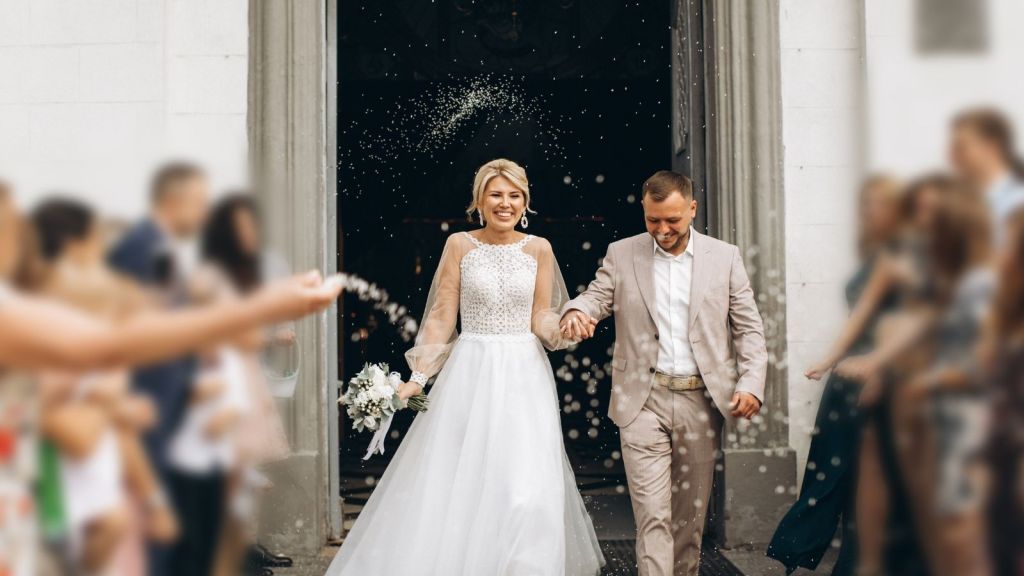 smiling bride and groom leaving church after they just got married