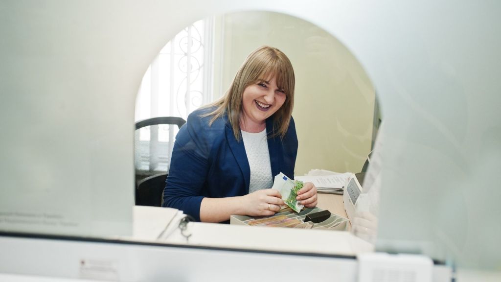 female bank teller laughing
