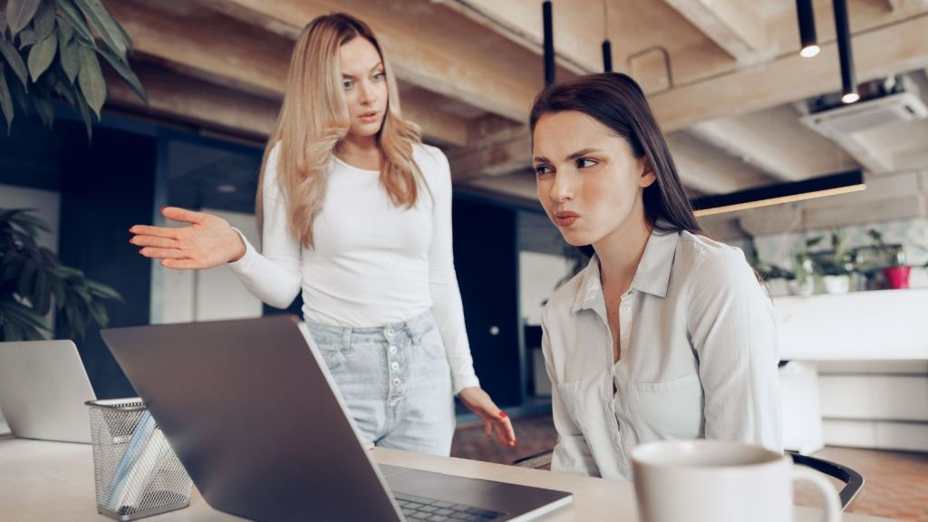 woman scolding female coworker
