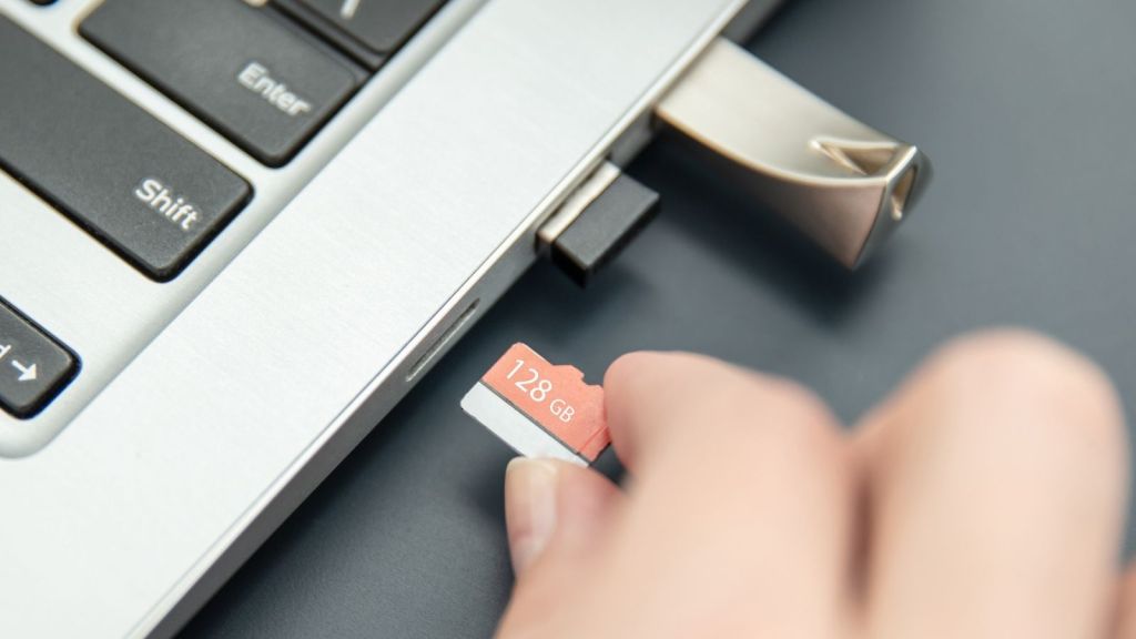 closeup of woman putting SD card in computer