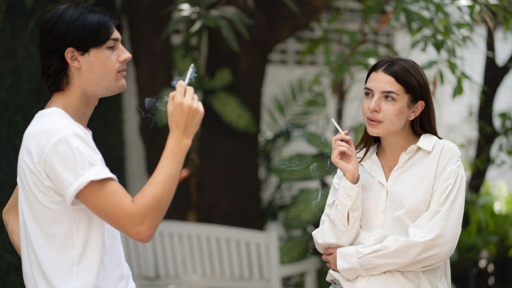 couple smoking cigarettes outside