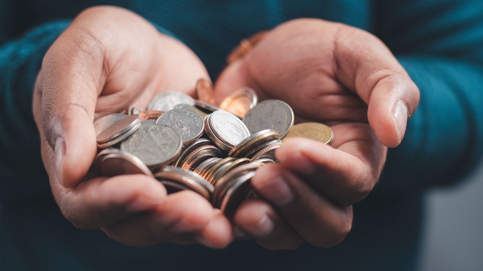 Warehouse Prankster Leaves Coins on Coworkers’ Desks, but the Joke Backfires as Everyone Catches On businessman holding coins in his hands
