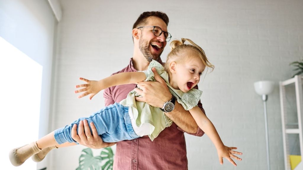 man holding little girl like an airplane