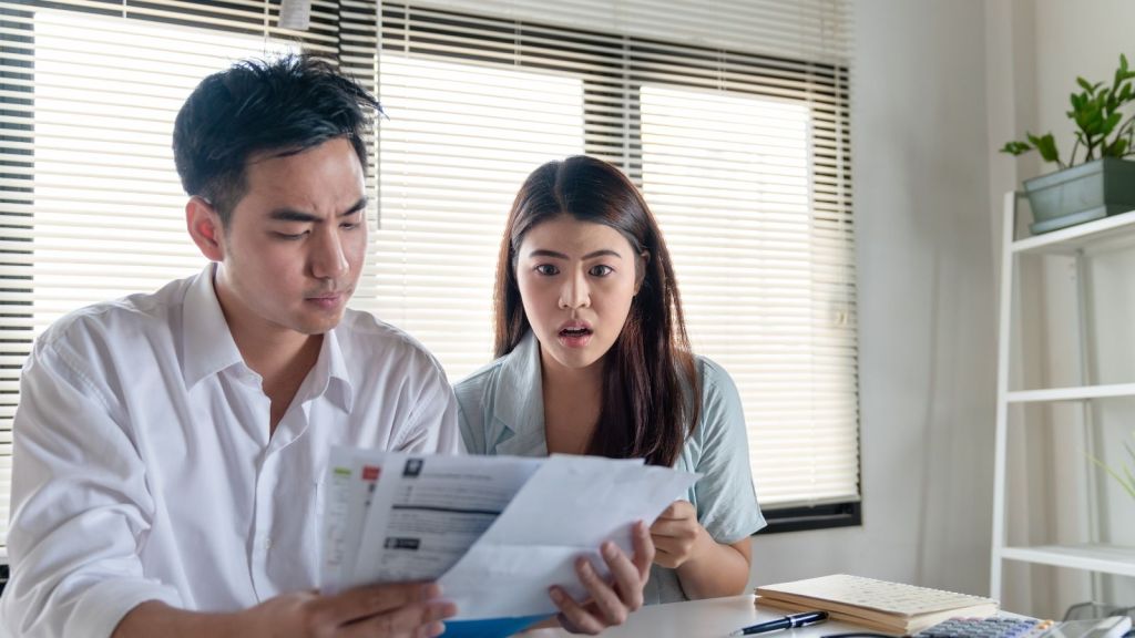 stressed out couple looking at bill