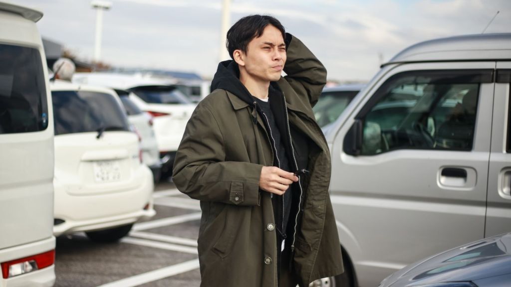 man standing in parking lot looking confused