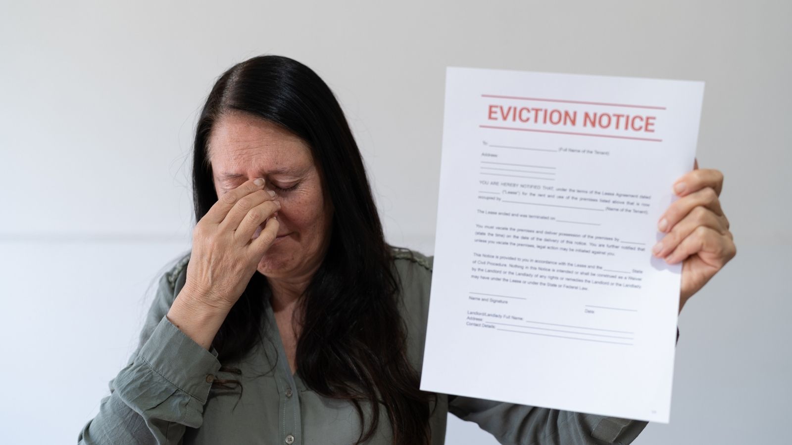Landlord Told Family to Leave for Two Months Over a Plumbing Issue — Now Hes Blaming Them for It and Trying to Evict Them upset woman holding an eviction notice