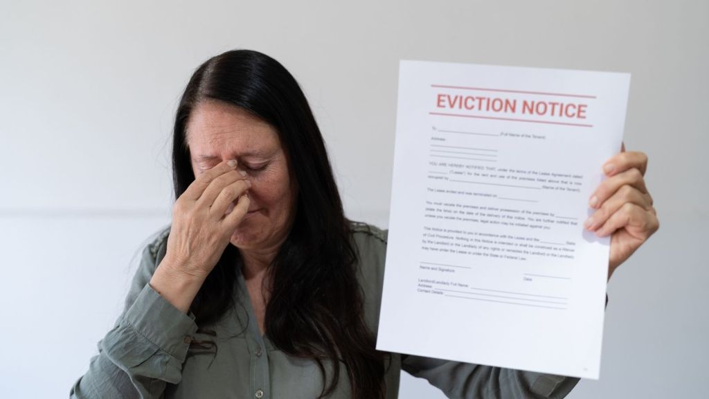 upset woman holding an eviction notice