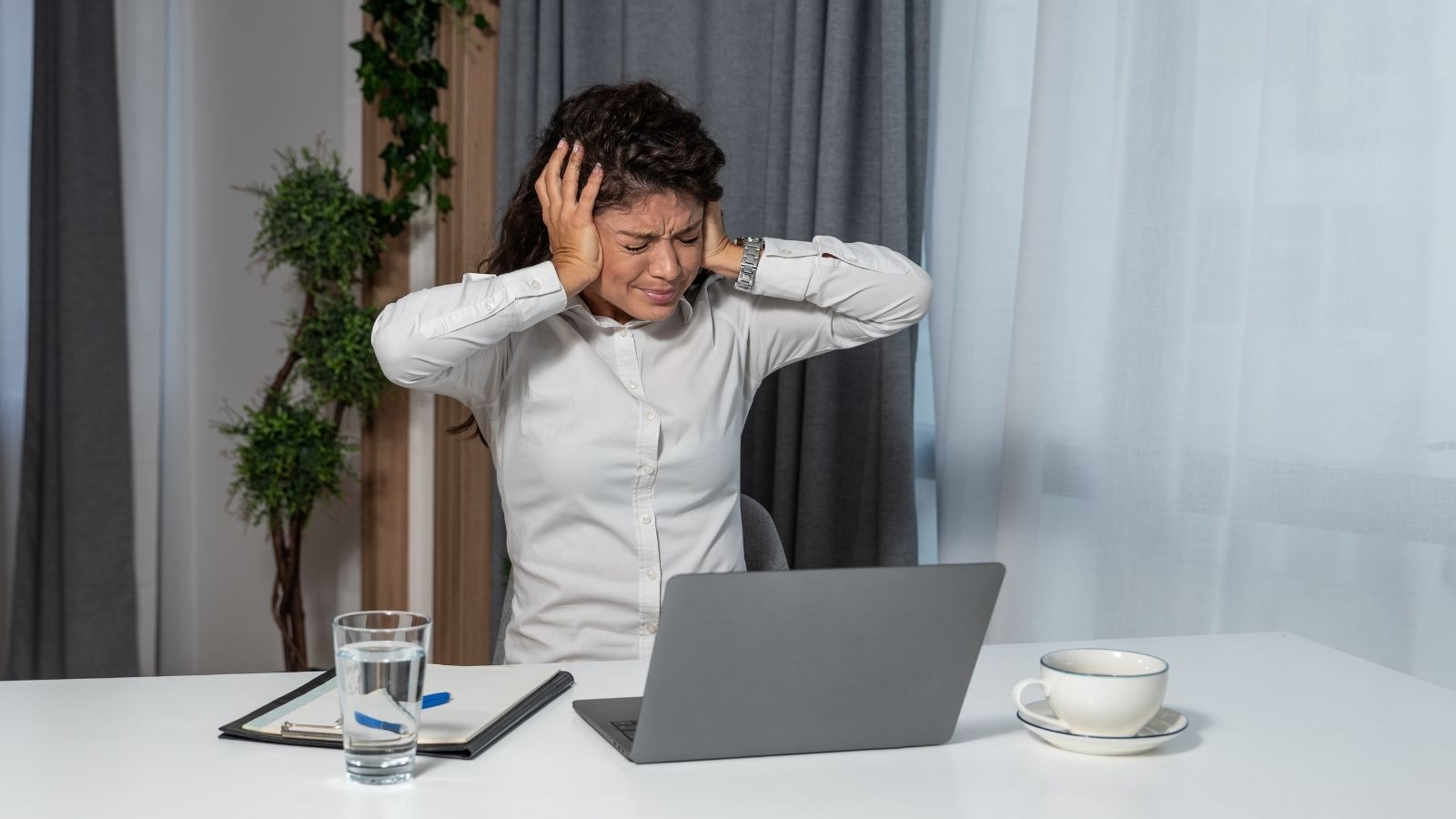 Music From a House Two Blocks Away Is So Loud a Couple Cant Work From Home frustrated woman covering her ears with her hands