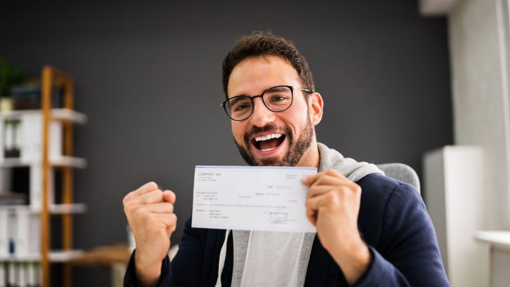 happy man holding a paycheck