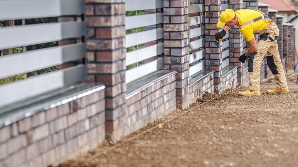 construction worker looking at a residential fence