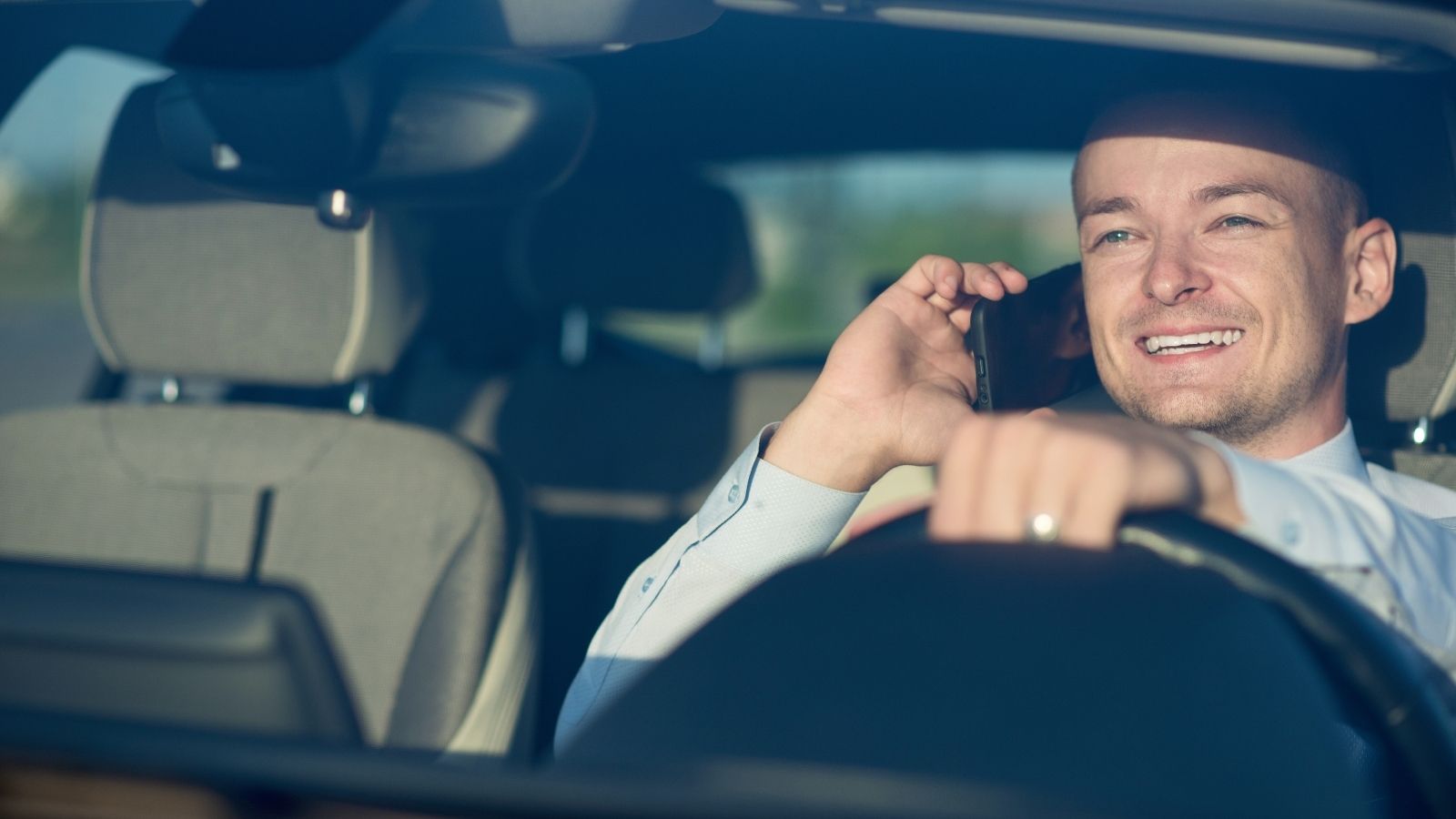 Sales Rep Doing the Work of Two People Gets Overtime, and the Owner Isn’t Happy About It smiling businessman talking on the phone while driving