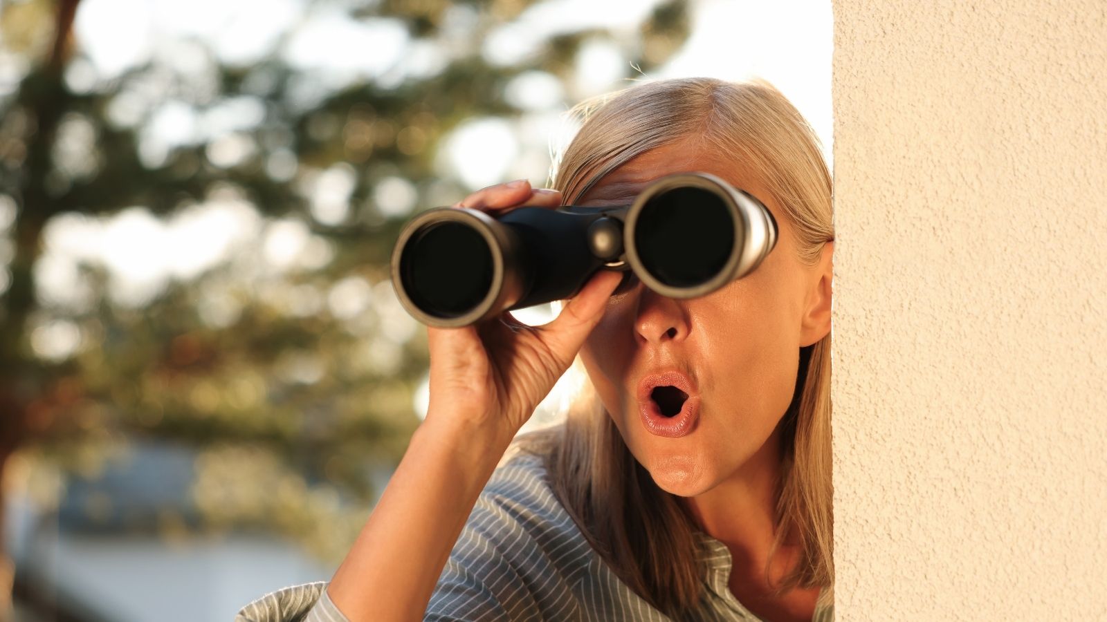 Neighbor Accused a Family of Damaging Her Fence — The Tire Tracks Tell a Different Story old woman spying on the neighbors with binoculars