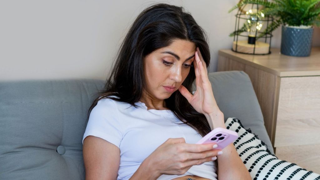 sad woman looking at her phone