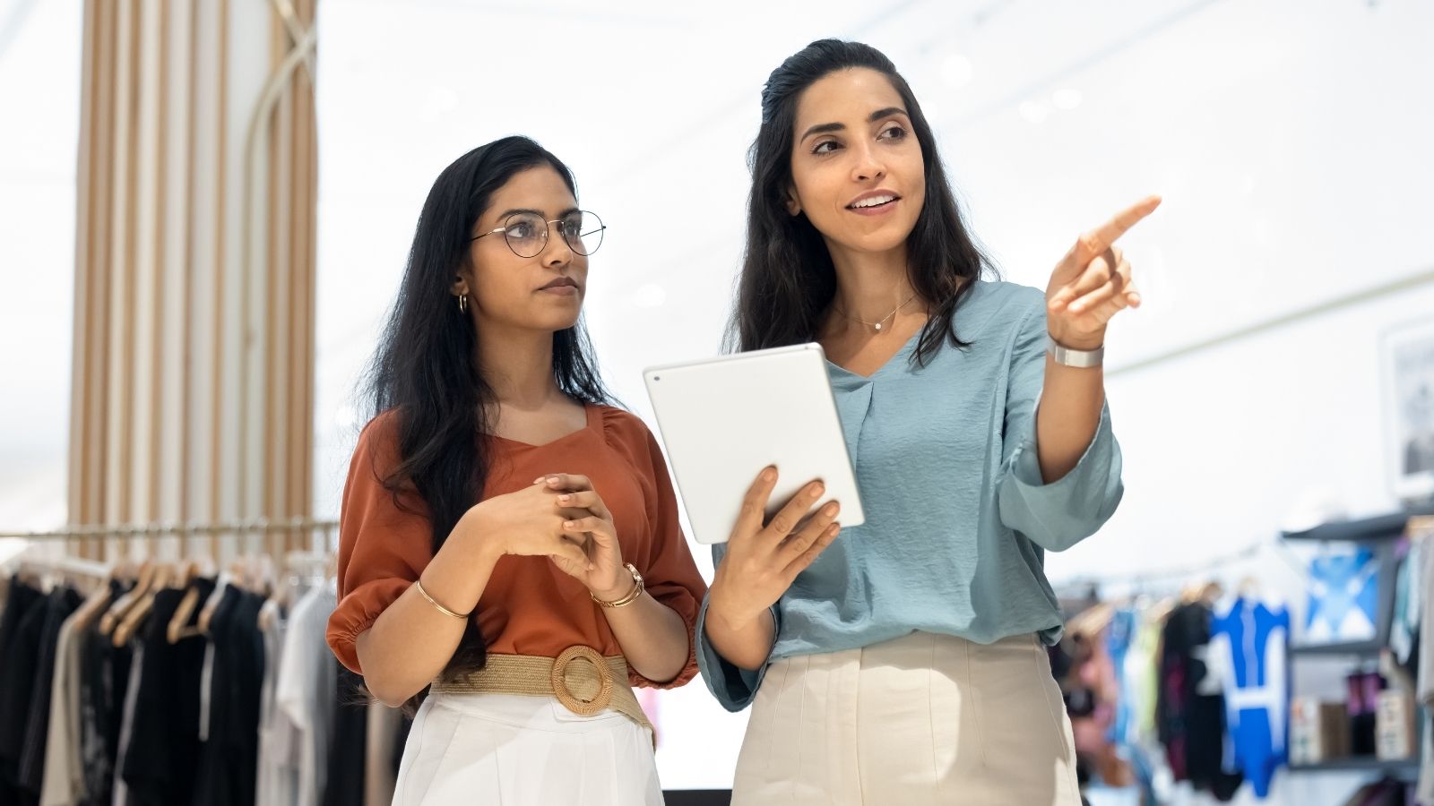 Retail Employee Gets Criticized by Supervisor for Not Being Tall Enough to Reach Merchandise two women working at a clothing store