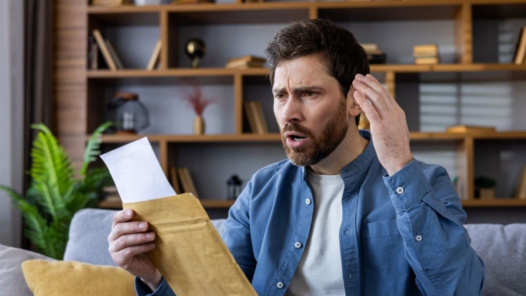 upset man looking at a letter