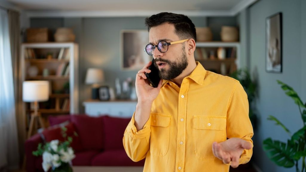 man in a yellow shirt talking on the phone