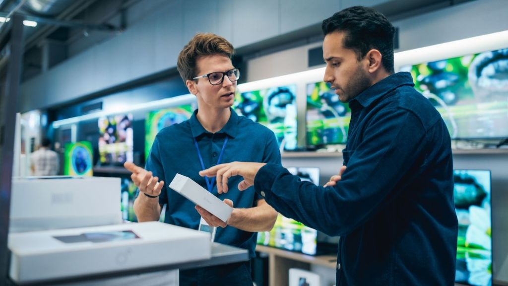 employee talking to customer in home electronics department
