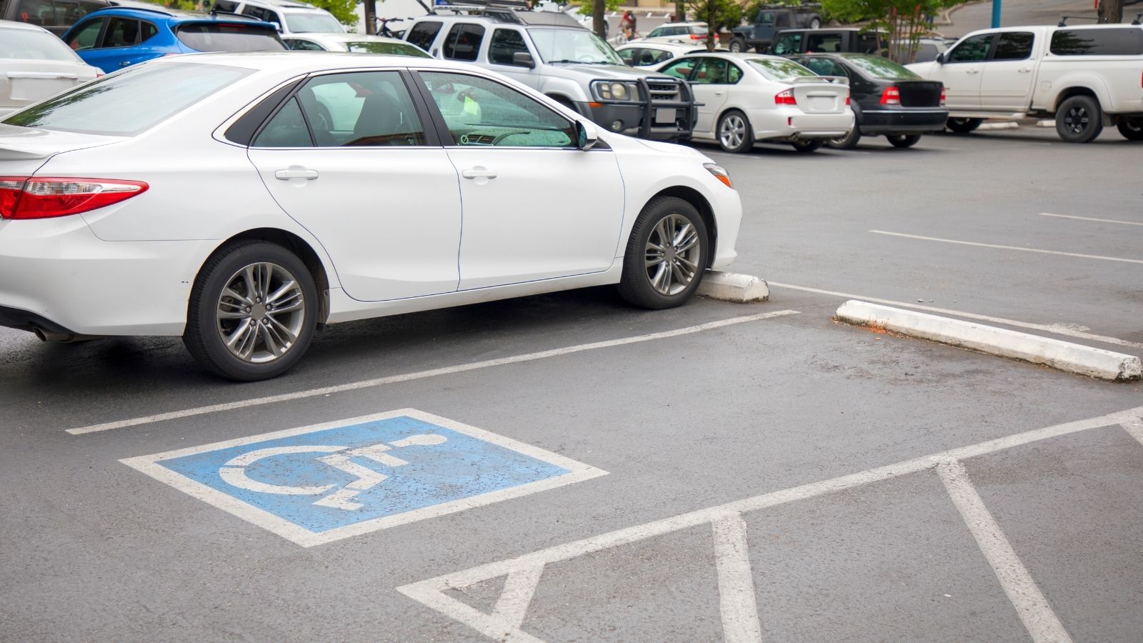 Woman Unsure Whether to Use Her Reserved Parking Spot Because It’s Still Marked as Handicap Accessible handicapped parking spot in a parking lot filled with cars