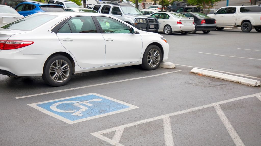 handicapped parking spot in a parking lot filled with cars